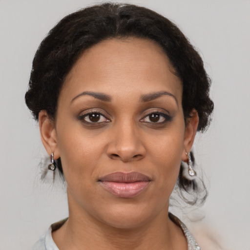 Joyful black young-adult female with medium  brown hair and brown eyes