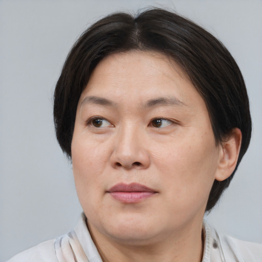 Joyful asian adult female with short  brown hair and brown eyes