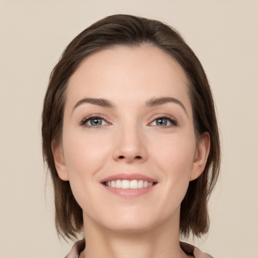 Joyful white young-adult female with medium  brown hair and grey eyes