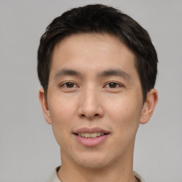 Joyful asian young-adult male with short  brown hair and brown eyes