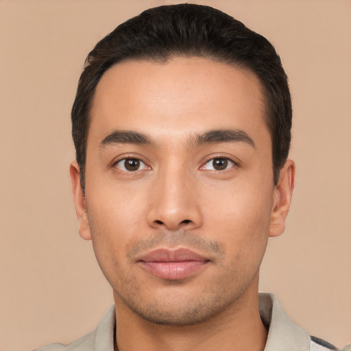 Joyful latino young-adult male with short  black hair and brown eyes