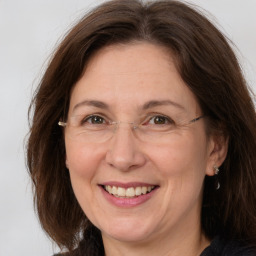 Joyful white adult female with long  brown hair and grey eyes