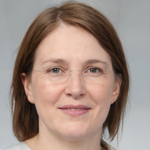 Joyful white adult female with medium  brown hair and grey eyes