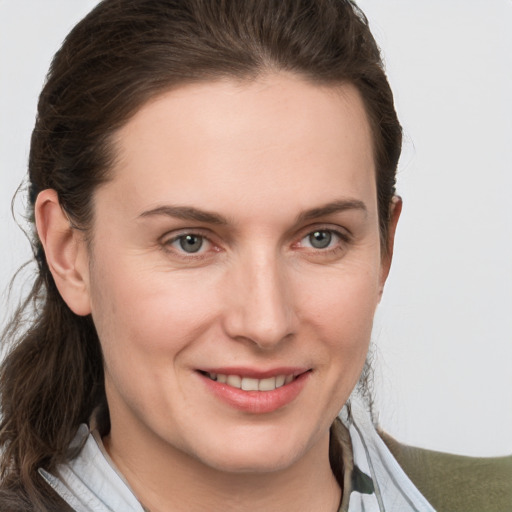 Joyful white young-adult female with medium  brown hair and grey eyes