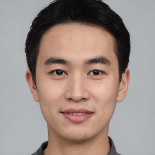 Joyful asian young-adult male with short  black hair and brown eyes