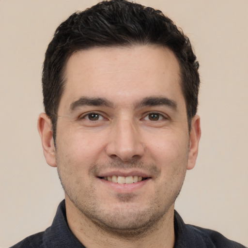 Joyful white young-adult male with short  black hair and brown eyes