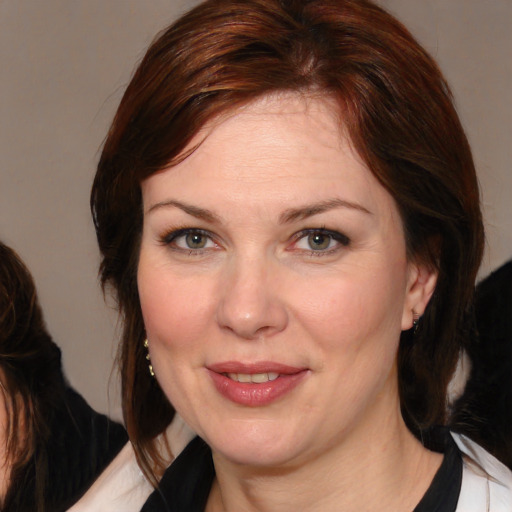 Joyful white adult female with medium  brown hair and brown eyes