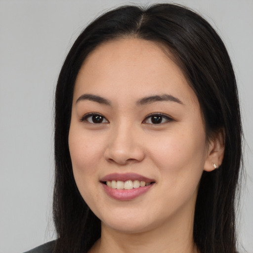 Joyful asian young-adult female with long  brown hair and brown eyes