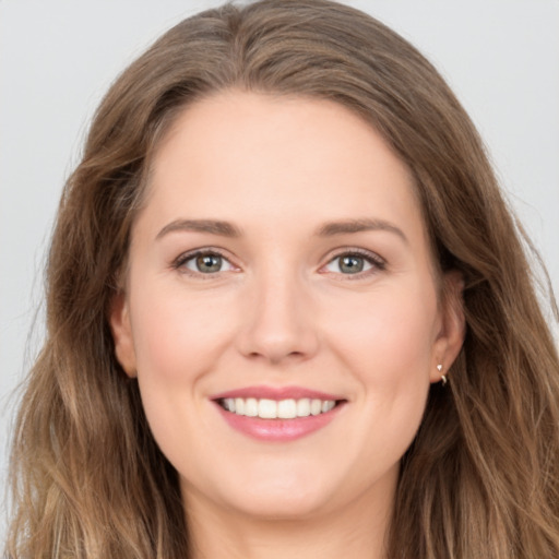 Joyful white young-adult female with long  brown hair and brown eyes