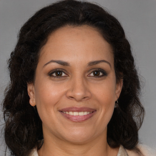 Joyful latino adult female with medium  brown hair and brown eyes