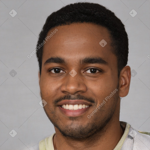 Joyful black young-adult male with short  black hair and brown eyes