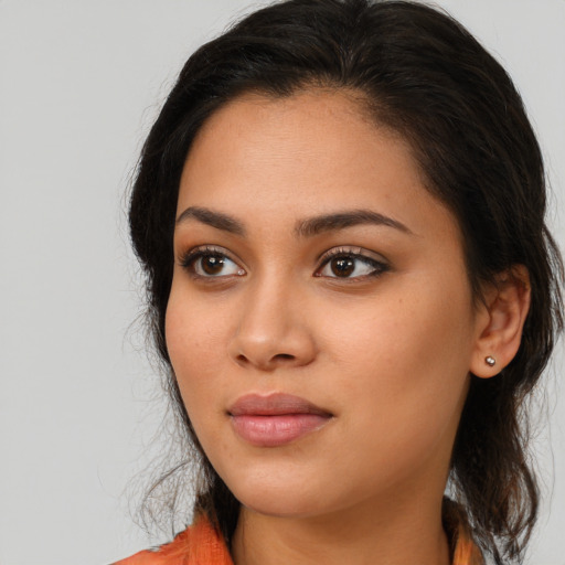 Joyful latino young-adult female with long  brown hair and brown eyes