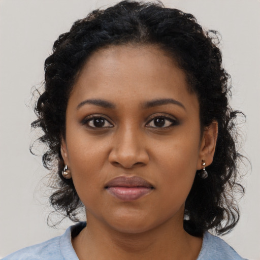 Joyful black young-adult female with long  black hair and brown eyes