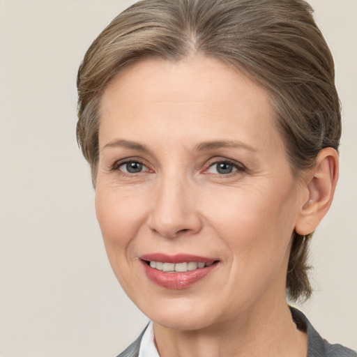 Joyful white adult female with medium  brown hair and grey eyes