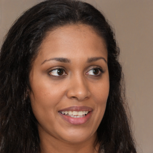 Joyful latino young-adult female with long  brown hair and brown eyes