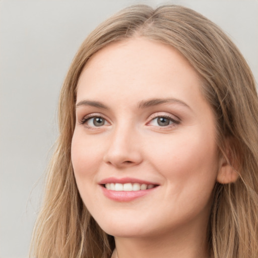 Joyful white young-adult female with long  brown hair and blue eyes