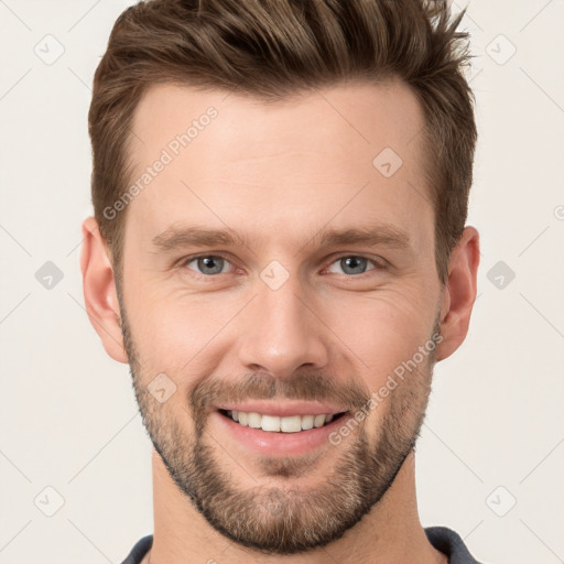 Joyful white young-adult male with short  brown hair and grey eyes