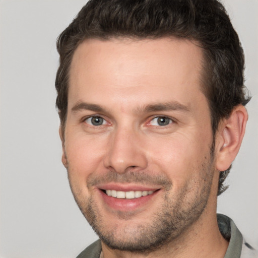 Joyful white young-adult male with short  brown hair and brown eyes