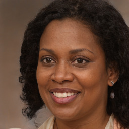 Joyful black adult female with long  brown hair and brown eyes