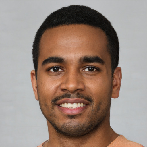 Joyful black young-adult male with short  black hair and brown eyes