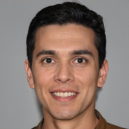 Joyful white young-adult male with short  black hair and brown eyes