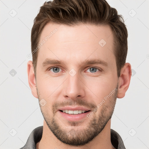 Joyful white young-adult male with short  brown hair and grey eyes