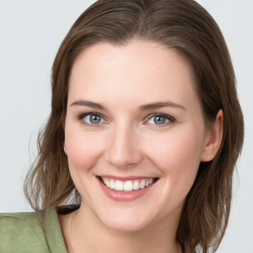 Joyful white young-adult female with medium  brown hair and grey eyes