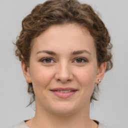 Joyful white young-adult female with medium  brown hair and green eyes