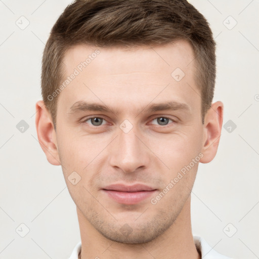 Joyful white young-adult male with short  brown hair and grey eyes