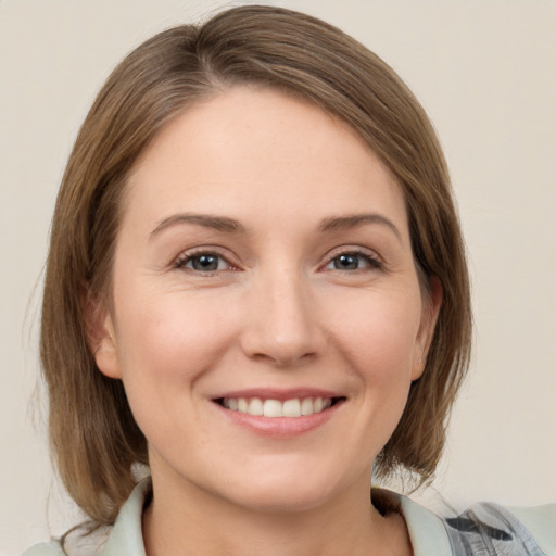 Joyful white young-adult female with medium  brown hair and grey eyes