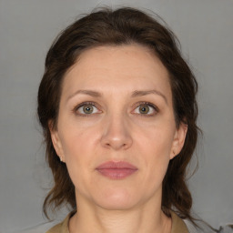 Joyful white adult female with medium  brown hair and grey eyes