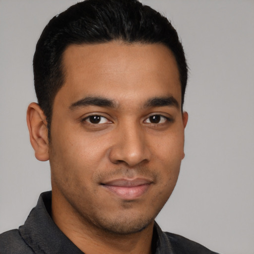 Joyful latino young-adult male with short  brown hair and brown eyes