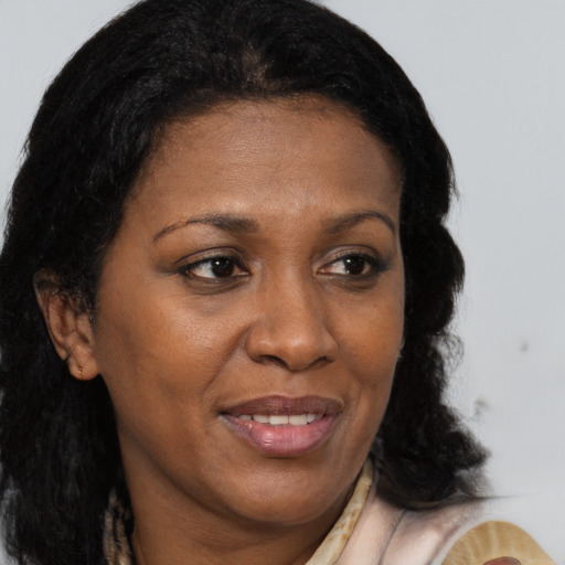 Joyful black adult female with medium  brown hair and brown eyes