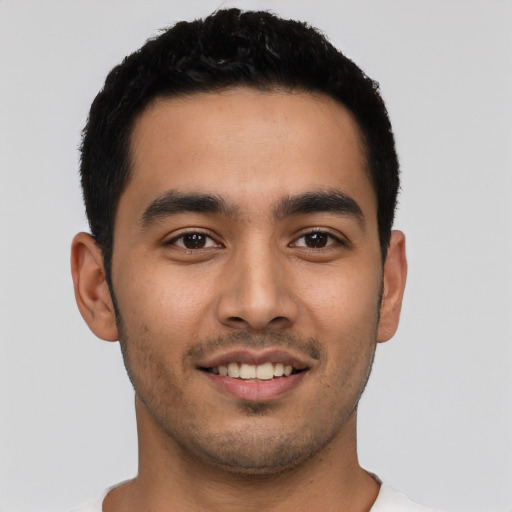 Joyful latino young-adult male with short  brown hair and brown eyes