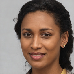 Joyful black young-adult female with long  brown hair and brown eyes