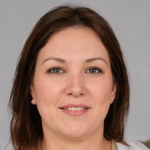 Joyful white adult female with medium  brown hair and grey eyes