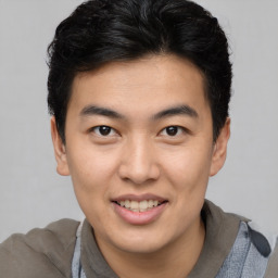 Joyful latino young-adult male with short  brown hair and brown eyes