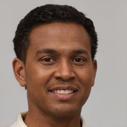 Joyful latino young-adult male with short  brown hair and brown eyes