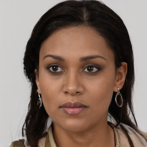 Joyful black young-adult female with long  brown hair and brown eyes