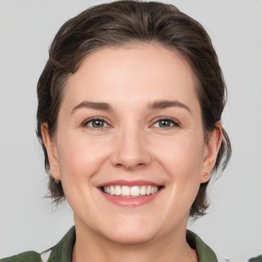 Joyful white young-adult female with medium  brown hair and grey eyes