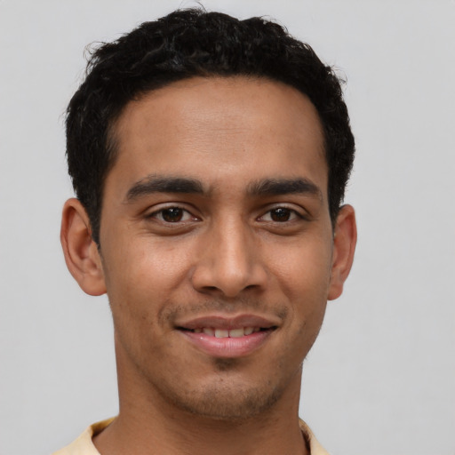 Joyful latino young-adult male with short  black hair and brown eyes