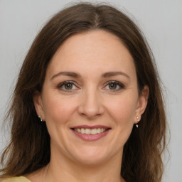 Joyful white adult female with medium  brown hair and grey eyes