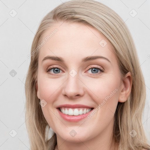 Joyful white young-adult female with long  brown hair and blue eyes