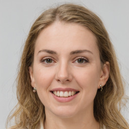 Joyful white young-adult female with long  brown hair and green eyes