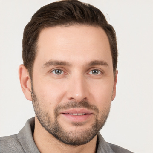 Joyful white young-adult male with short  brown hair and grey eyes