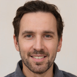 Joyful white adult male with short  brown hair and grey eyes