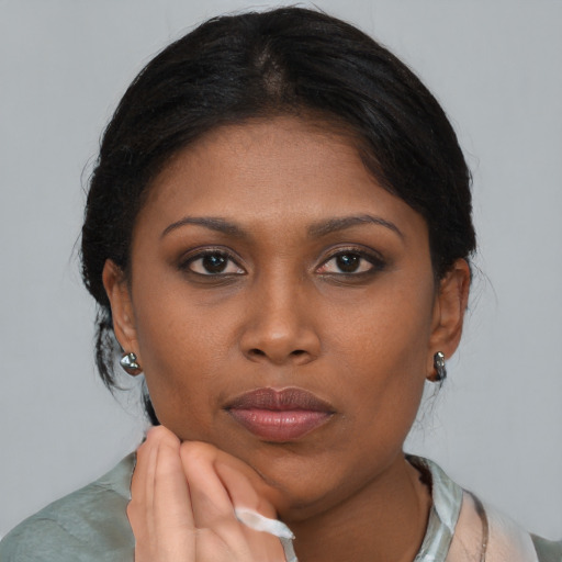 Neutral black young-adult female with medium  brown hair and brown eyes