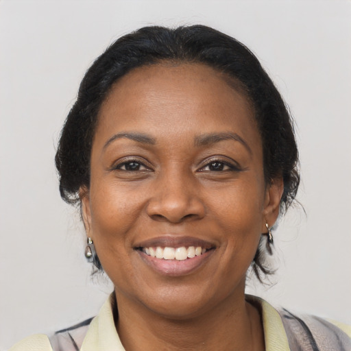Joyful black adult female with medium  brown hair and brown eyes