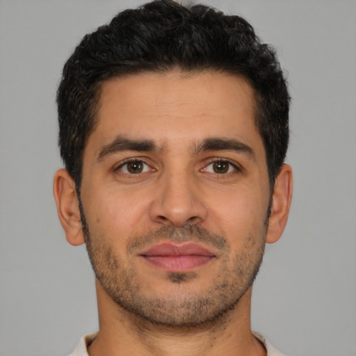 Joyful latino young-adult male with short  brown hair and brown eyes