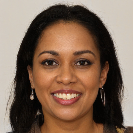 Joyful black young-adult female with long  brown hair and brown eyes